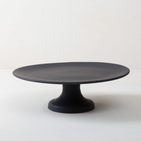 Cake Stand Ernesta Matt Black L | Our medium size elevated cake stand Ernesta rests on a 13 cm high foot and has a diameter of 35 cm. On the matt black serving tray there is enough room to present and arrange cakes, cupcakes, sushi and other delicacies on the table or at the modern buffet. The serving trays are handcrafted from high-quality terracotta and glazed matt black, obviously food safe.These cake stands are available in three different sizes as well as a matt white serving tray. They can be wonderfully combined for presentations. | gotvintage Rental & Event Design