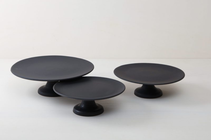  | Our medium size elevated cake stand Ernesta rests on a 13 cm high foot and has a diameter of 35 cm. On the matt black serving tray there is enough room to present and arrange cakes, cupcakes, sushi and other delicacies on the table or at the modern buffet. The serving trays are handcrafted from high-quality terracotta and glazed matt black, obviously food safe.
These cake stands are available in three different sizes as well as a matt white serving tray. They can be wonderfully combined for p... | 