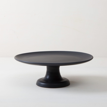 Cake Stand Ernesta Matt Black M | Our small elevated round cake stand Ernesta rests on a 12 cm high foot and has a diameter of 32 cm. On the matt black serving tray there is space to present and arrange cakes, cupcakes, sushi and other delicacies on the table or at the modern buffet. The serving trays are handcrafted from high-quality terracotta and glazed matt black, obviously food safe.These cake stands are available in three different sizes as well as a matt white serving tray. They can be wonderfully combined for presentations. | gotvintage Rental & Event Design