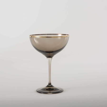 Champagne Coupe Acadia Smoked Gold Rim 21cl | We rent out the champagne coupe Acadia Smoke, a champagne glass with a golden rim and a smoked glass look. Whether for an elegant dinner party, a festive reception or a minimalist wedding - champagne coupe Acadia Smoke is definitely the colored glass for your event.You can rent further colored glasses of the Acadia series with smoked glass effect and gold rim to match the champagne glass. The complete Acadia Smoke series includes water tumbler, white wine glass, red wine glass and champagne glass. | gotvintage Rental & Event Design